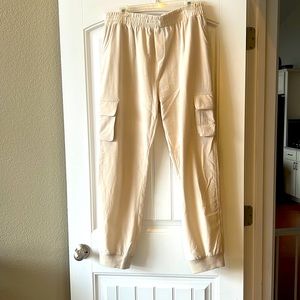 Cream colored pants with cargo pockets. Material is linen like. Feels satin.
